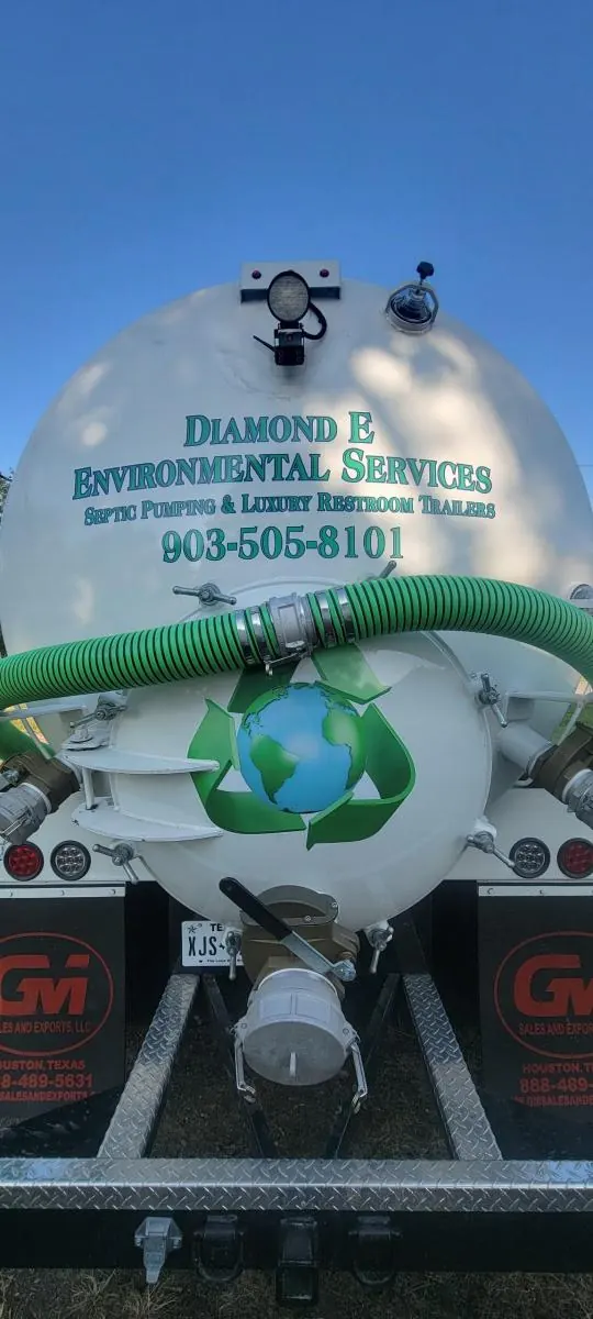 Rear of the Diamond E vacuum tank with company lettering and coiled green suction hose